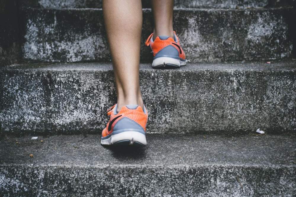 Walking up the cement stairs in sneakers.